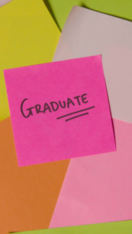 Vertical-Video-Education-Concept-Of-Revolving-Sticky-Notes-With-Graduate-Written-On-Top-Note